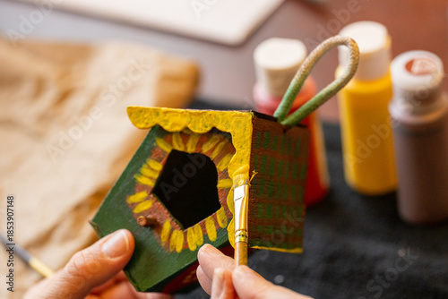 Canvas Print Shallow DOF image of woman painting a small birdhouse arts and crafts concept
