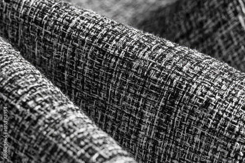 Close up texture of woven grey boucle fabric featuring intricate thread detail and rough pattern creating moody atmosphere perfect for abstract background wallpaper or textile design project