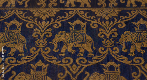 Golden embroidered elephants on dark blue silk fabric with decorative floral scrollwork and ornate patterns