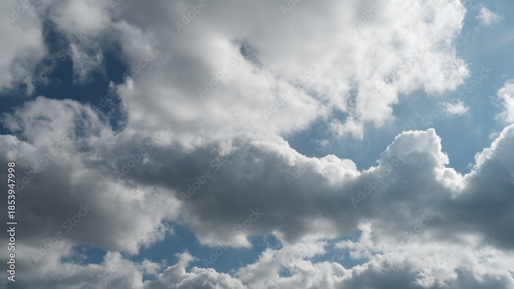Fototapeta premium Beautiful blue sky background with fluffy white cloud formations on sunny day. peaceful and calm scene shows natural light and serene weather, perfect for any project
