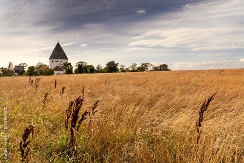 golden autumn field with the historic St. Olaf Church on the Danish island of Bornholm