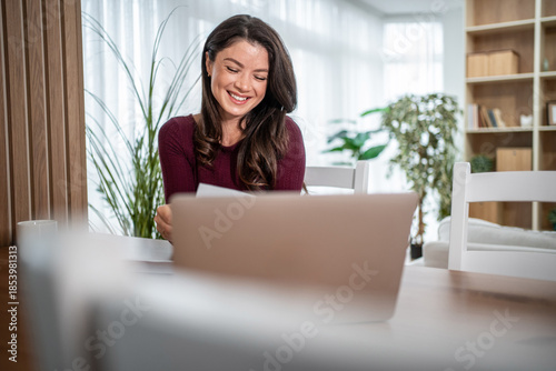 Fotografie Happy woman working from home using laptop