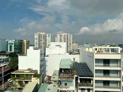 Rooftop view of the Ho Chi Minh City skyline featuring dense urban development, solar-equipped low-rise buildings, and modern skyscrapers, December 23, 2025. 