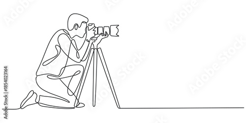One line drawing of photographer kneeling with camera on tripod