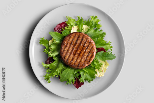 Hamburger with mixed salad on a round white plate