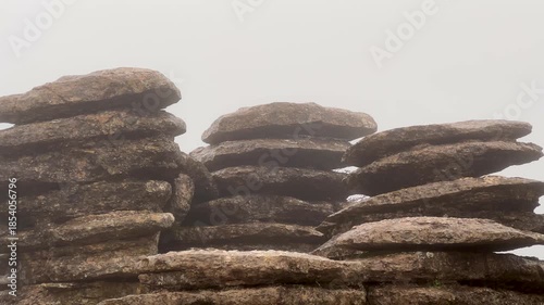 Mysterious fog moving through the unique karst landscape of El Torcal de Antequera. This nature reserve in Malaga, Spain, features impressive stacked limestone rock formations
