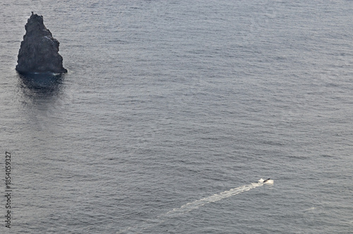 Easter Island, Valparaiso, Chile. May 28, 2013: A solitary boat travels near a large rock formation off the coast of Easter Island.