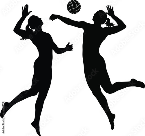 Silhouettes of two female volleyball players in action, jumping and hitting a volleyball during a game