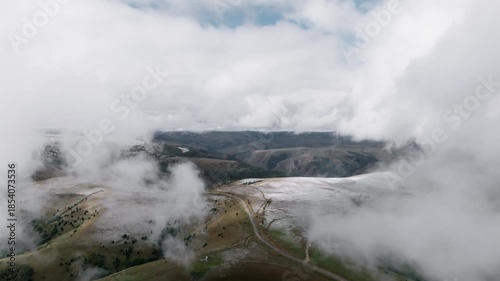 Aerial view of movement through clouds or very close to clouds in mountainous areas