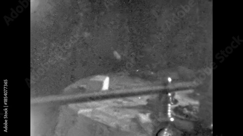 Elderly people sitting at dining table at home. Grainy, noisy analog home video capturing abstract everyday domestic life and shared routine. Imperfect aging. Archival retro 1970s. Vintage archive