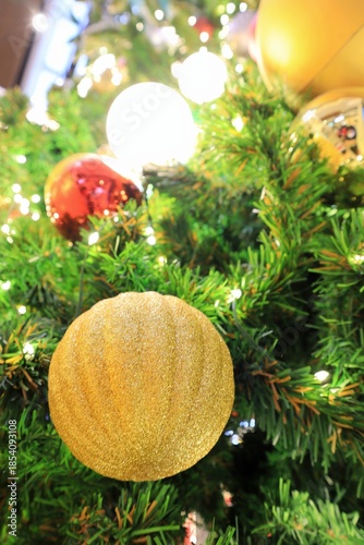 Christmas fir tree with decoration, golden balls and lighting. Selective focus with bokeh of christmas tree background. Christmas and happy new year background concept.