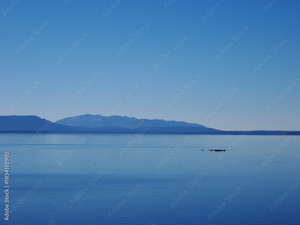 Fototapeta premium Calm Blue Waters of Yellowstone Lake Against Mountain Skyline