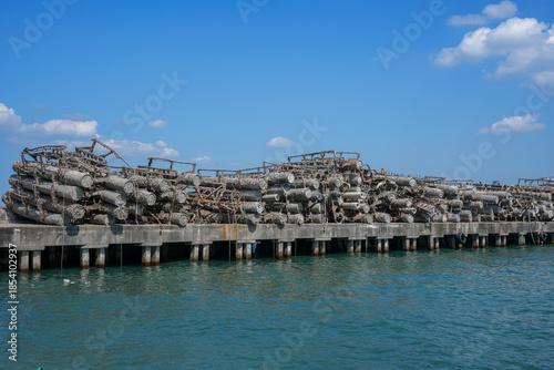 Rusty, barnacle-covered metal pipes at an abandoned harbor symbolize the environmental impact of industry on marine ecosystems.