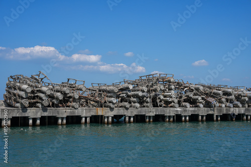 Rusty, barnacle-covered metal pipes at an abandoned harbor symbolize the environmental impact of industry on marine ecosystems.