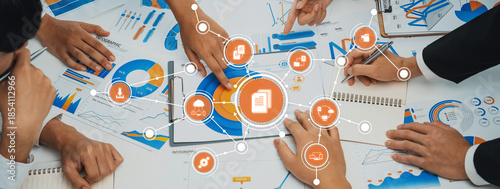 A dynamic workspace featuring a diverse team engaged in a collaborative business strategy session, utilizing charts, diagrams, and digital resources to drive innovation. Amity