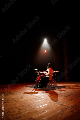 Professional drummer performing solo on a large stage under spotlight
