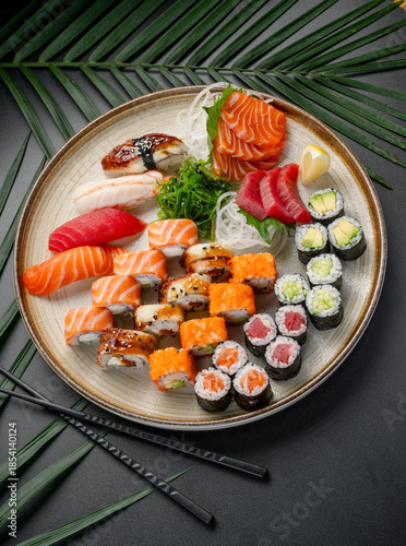Large Sushi and Sashimi Platter with Edamame and Crab. An extensive platter displays a full selection of sushi, sashimi, and maki rolls, including crab and edamame, surrounding seaweed.