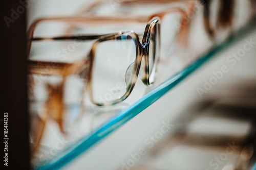 Eyeglass frames on display shelf. Closeup of optical frames arranged on transparent retail stand