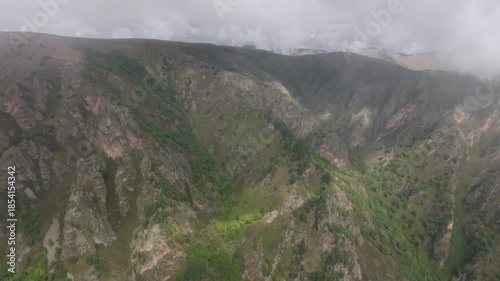 Aerial view of movement through clouds or very close to clouds in mountainous areas