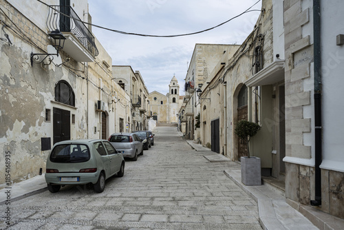 Canvas-taulu Typical buildings along a narrow street in Vieste’s old town, partly built on cliffs, bustling with tourists on the Mediterranean coast of Gargano, Apulia, Italy