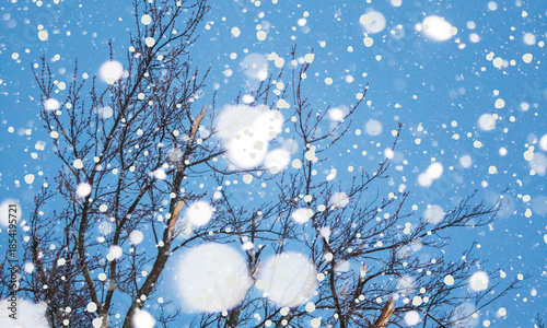 Heavy snowfall and bright bokeh effect obscuring tree branches against a clear blue sky on transparent background