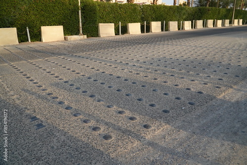 Speed bump on asphalt road closeup, Metal road studs for traffic calming device for slowing down according to speed limit. City of El Quseir on the Red Sea, Northern Egypt, Africa.