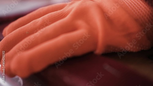 Close up of furniture restorer hands removing old fabric material from vintage chair seat for reupholstery