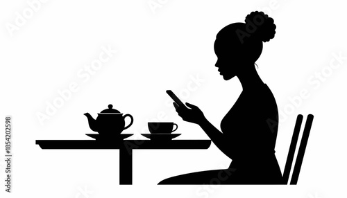 Silhouette of a woman using her smartphone while drinking tea at a table.