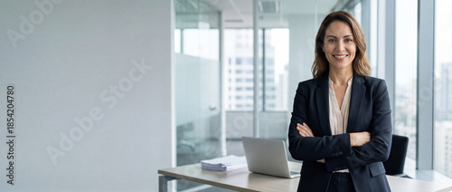Beautiful hispanic senior business woman with crossed arms smiling at camera. European or latin confident mature middle age leader female businesswoman standing at office workplace, copy space. 