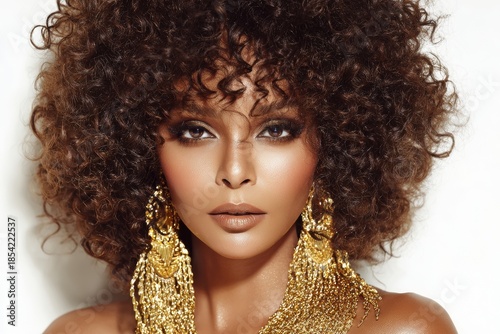 Model Showcases Curly Hair and Golden Earrings in Soft Lighting Against White Background for a Stunning Beauty Shot
