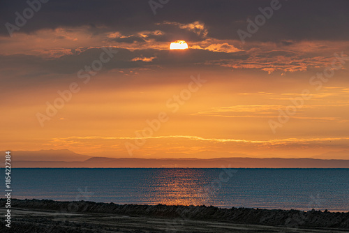 sole che sorge all'alba sopra il mare Adriatico e colora l'ambiente di arancione, visto dalla costa della regione Veneto