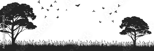 Silhouette of acacia trees with birds flying and tall grass