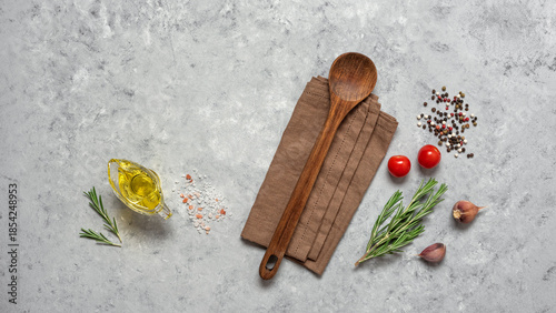 A culinary backdrop with spices, a wooden spoon, and a linen napkin. Top view, flat lay, copy space.
