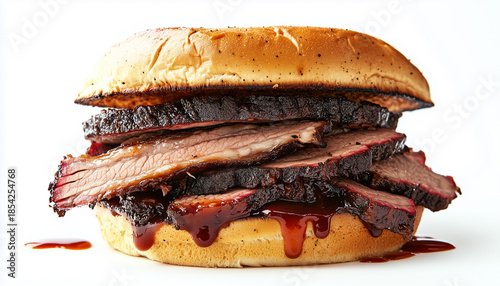 Juicy tri tip beef sandwich on a bun with barbecue sauce. Sliced meat is stacked high on soft bread. This delicious meal is perfect for