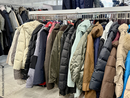 Display Of Muted Winter Outerwear, Rack Featuring Nylon And Down Insulated Garments For Winter Seasons, Exhibition Of Various Muted Coats And Jackets With Quilted Textures And Padding