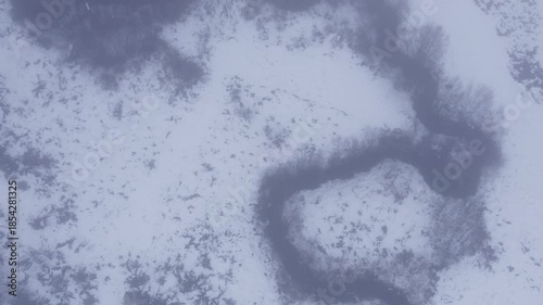 Flying Over a Meandering River Through the Mist in Winter