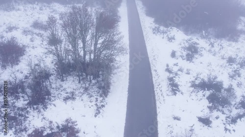 Flying Along an Empty Road Through the Winter Mist