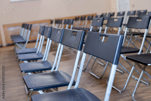 Foto folding black chairs stand in a row on a white wooden floor outside