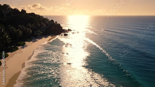 Stunning aerial view of a beautiful beach with golden sunlight and ocean waves.