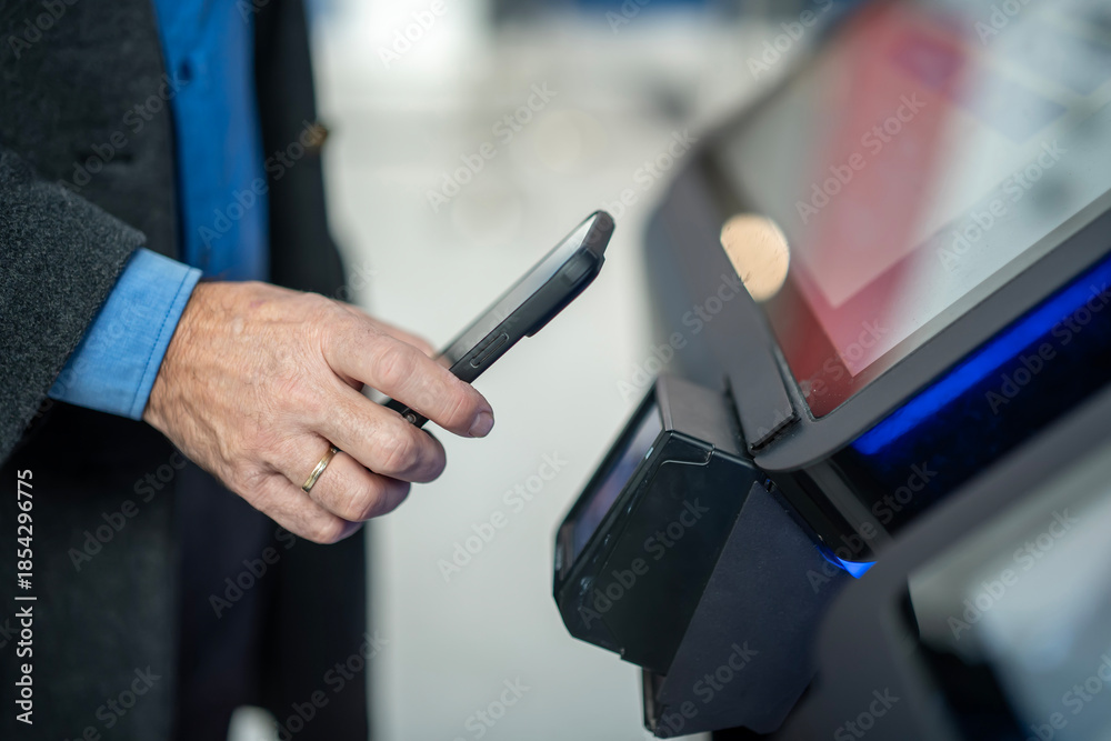 Obraz premium Person paying contactless with smartphone at terminal