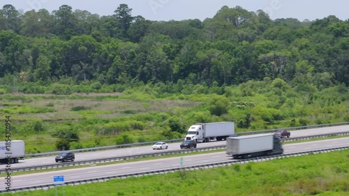 Big truck tractor trailers hauling cargo on busy American highway.