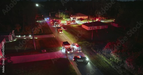 Fire engine trucks and ambulance vehicles responding to fire alarm at night. Investigation of carbon monoxide gas hazard at private house in USA.