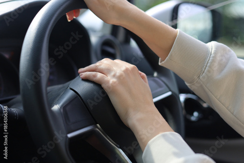 Close up Hands on the steering wheel of the car and honking.