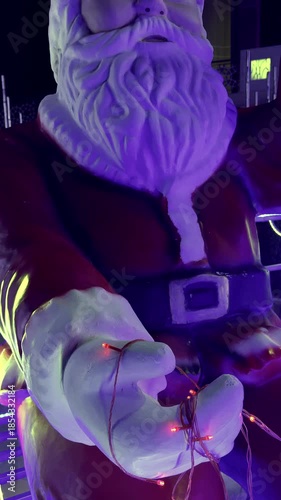 Santa Claus statue holding red string lights