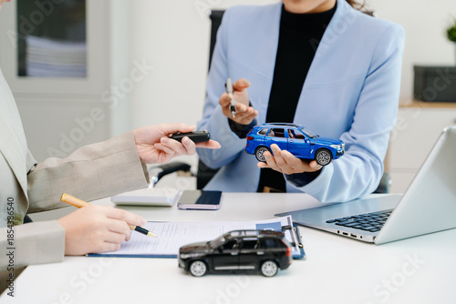 Car insurance consultation using smartphone and documents. Advisor and customer reviewing digital insurance service, auto policy, finance, technology