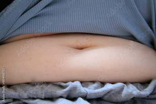 太った女性のおなかを手で抑える　腹　肉　脂肪　体型