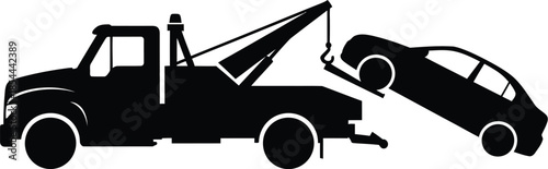 Silhouette of a tow truck lifting a car