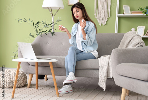 Diabetic young woman with lancet pen and glucose sensor receiving online cons...