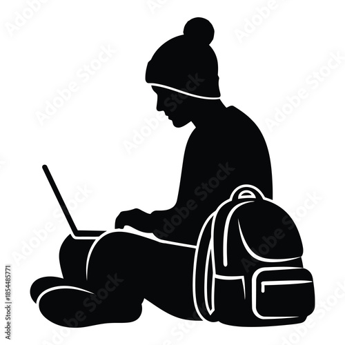 Silhouette of a student wearing a warm hat working diligently on a portable computer with a backpack nearby on white background