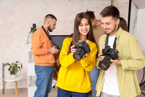 Happy photographers with cameras during courses in studio